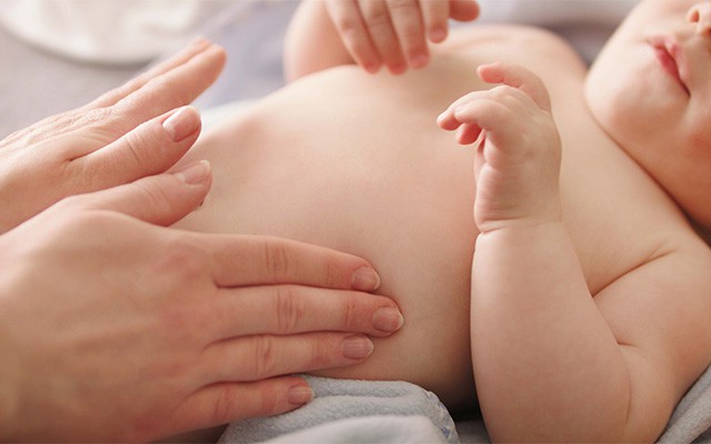 Babybauch wird sanft mit H&auml;nden massiert.